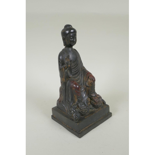 188 - A Chinese bronze Buddha seated on a throne, with the remnants of gilt and copper patina, 23cm high