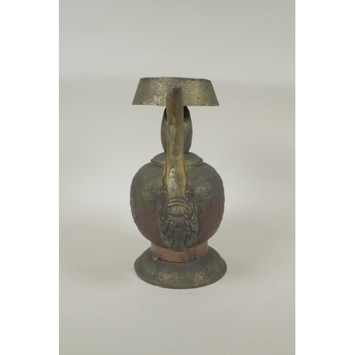 191 - A Tibetan embossed bronzed metal pourer with raised kylin decoration, 26cm high