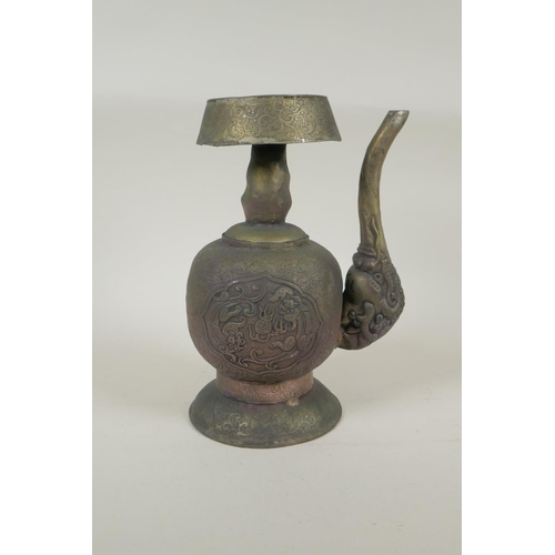 191 - A Tibetan embossed bronzed metal pourer with raised kylin decoration, 26cm high