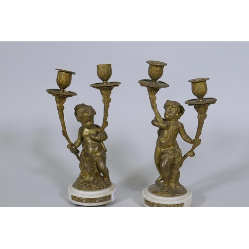 227 - A pair of C19th French ormolu bronze two branch candelabra in the form of putti bearing cornucopia, ... 