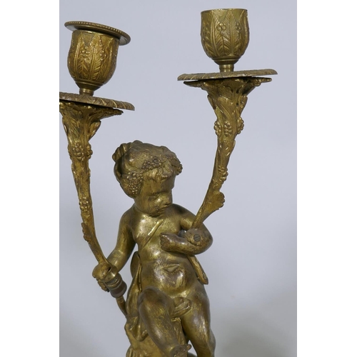 227 - A pair of C19th French ormolu bronze two branch candelabra in the form of putti bearing cornucopia, ... 