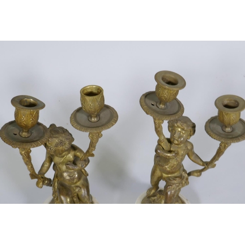 227 - A pair of C19th French ormolu bronze two branch candelabra in the form of putti bearing cornucopia, ... 