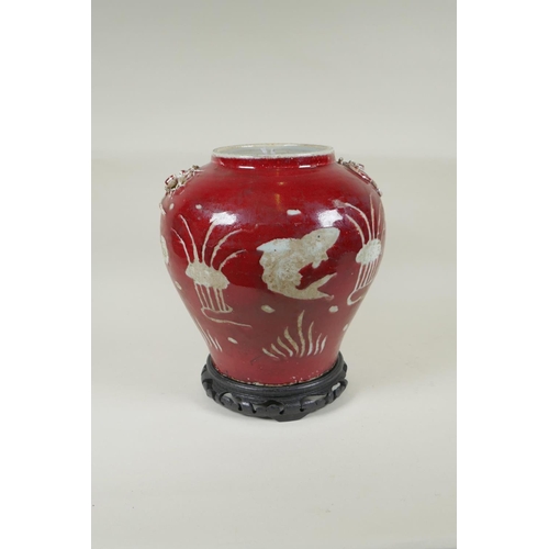 238 - A Chinese red and white porcelain baluster vase, decorated with carp in a lotus pond, on a carved ha... 