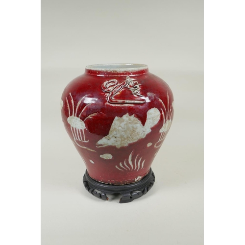 238 - A Chinese red and white porcelain baluster vase, decorated with carp in a lotus pond, on a carved ha... 