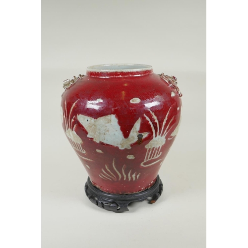 238 - A Chinese red and white porcelain baluster vase, decorated with carp in a lotus pond, on a carved ha... 