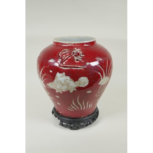 238 - A Chinese red and white porcelain baluster vase, decorated with carp in a lotus pond, on a carved ha... 