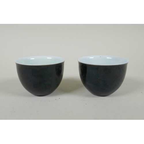 245 - A pair of Chinese black glazed porcelain tea bowls, 4 character mark to base, 6.5cm diameter