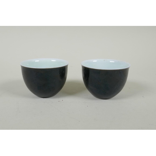 245 - A pair of Chinese black glazed porcelain tea bowls, 4 character mark to base, 6.5cm diameter