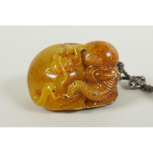 258 - A Chinese reconstituted amber soapstone elephant and monkey pendant/toggle, 7cm long