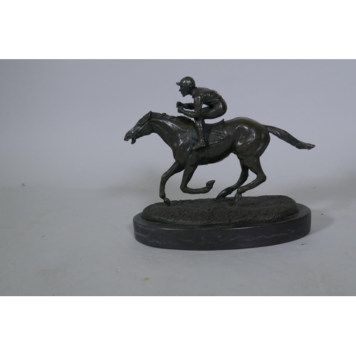 27 - A bronze figure of a jockey on a racehorse, inscribed Coreira, mounted on a slate base, 24cm high