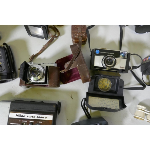 300 - A quantity of vintage cameras, film cameras and equipment, including a Kodak 255X Instamatic, a Koda... 