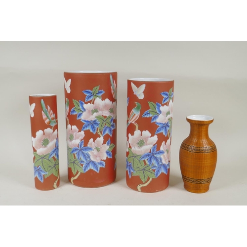 302 - A graduated set of three Chinese iron red ground porcelain cylinder vases with floral decoration, AF... 