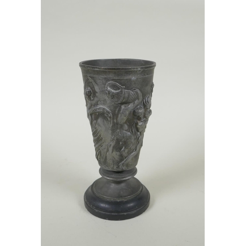 31 - An antique French Grand Tour pewter goblet on a slate socle, with raised Greco Roman figural decorat... 