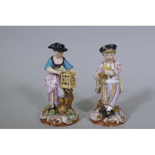 36 - A pair of Continental hard paste porcelain figures, boy with a bird and a birdseller, factory mark t... 