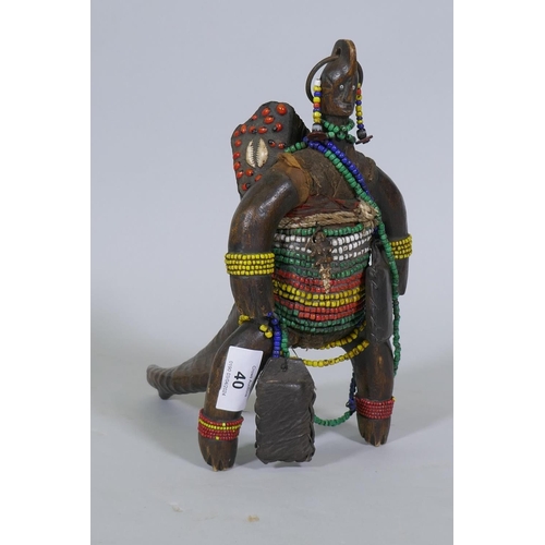 40 - An African doll figure, bound with beads to a horn stand, 26cm high