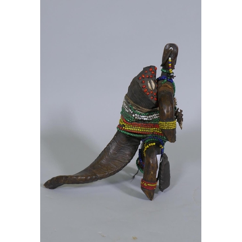 40 - An African doll figure, bound with beads to a horn stand, 26cm high