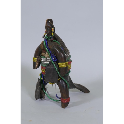 40 - An African doll figure, bound with beads to a horn stand, 26cm high