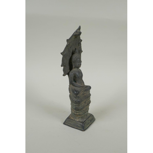 52 - A Cambodian filled bronze figure of Buddha seated on a cobra throne, 22cm high