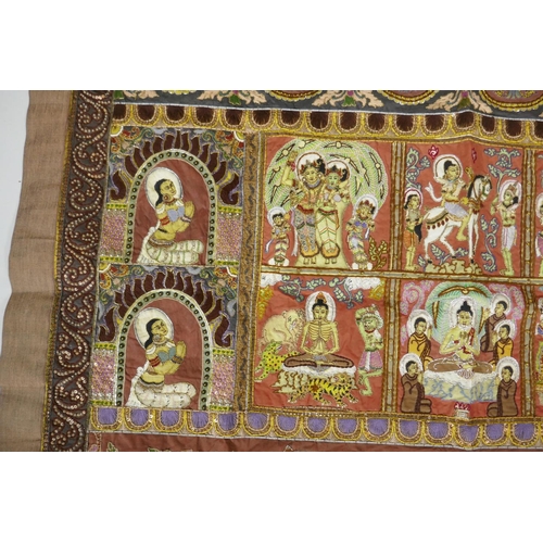 74 - An antique Tibetan embroidered and beaded silk textile hanging, decorated with depictions of Buddha,... 