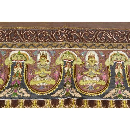 74 - An antique Tibetan embroidered and beaded silk textile hanging, decorated with depictions of Buddha,... 