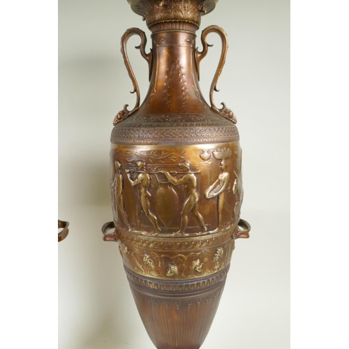 77 - After Barbedienne, a pair of bronze Grand Tour style urns with two handles and raised figural decora... 