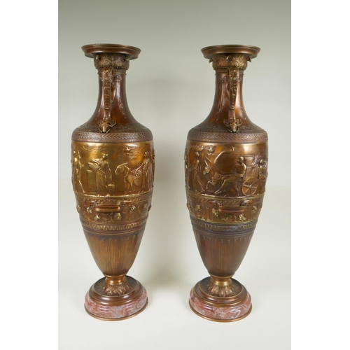 77 - After Barbedienne, a pair of bronze Grand Tour style urns with two handles and raised figural decora... 