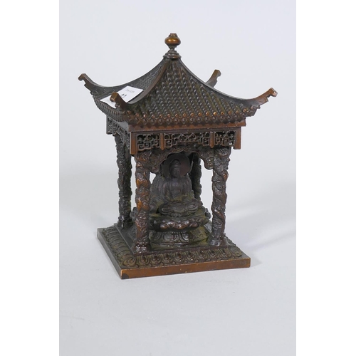 92 - A bronze model of a shrine with pagoda roof and three Buddhas, 15cm high