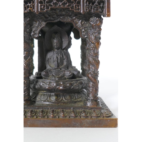 92 - A bronze model of a shrine with pagoda roof and three Buddhas, 15cm high