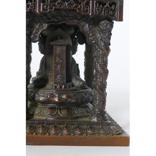 92 - A bronze model of a shrine with pagoda roof and three Buddhas, 15cm high