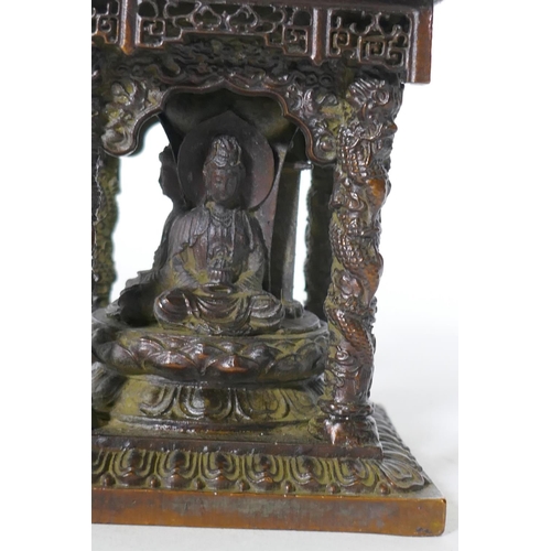 92 - A bronze model of a shrine with pagoda roof and three Buddhas, 15cm high