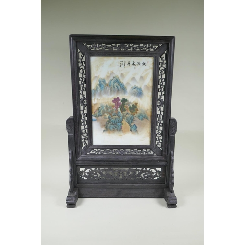 95 - A Chinese porcelain and carved hardwood table screen decorated with a mountain landscape, 68cm high