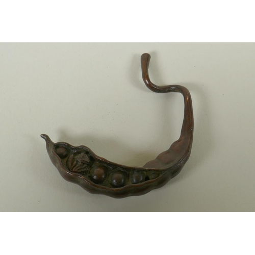 99 - A Japanese style bronze okimono of a frog nestled in a pea pod 7cm long