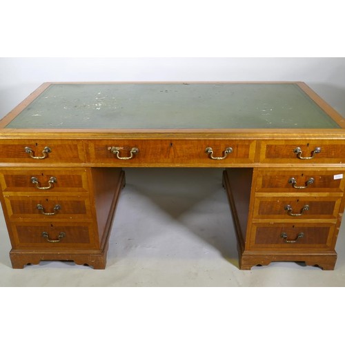 1112 - A Georgian style mahogany pedestal partner's desk, with nine drawers and two cupboards, brass swan n... 