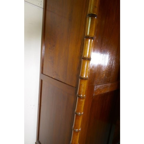 1120 - A Dutch C19th polished pitch pine knockdown armoire, with two doors flanked by faux bamboo columns, ... 