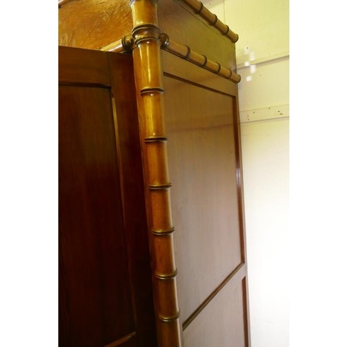 1120 - A Dutch C19th polished pitch pine knockdown armoire, with two doors flanked by faux bamboo columns, ... 