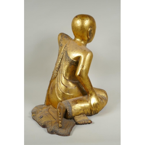 234 - A carved and gilt Thai figure of a seated Buddha, the robes set with decorative stones, 40cm high