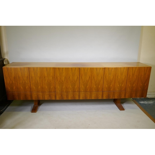 1004 - A mid century Danish style rosewood sideboard, with six cupboards over six drawers, the interior ven... 