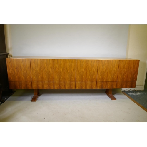 1004 - A mid century Danish style rosewood sideboard, with six cupboards over six drawers, the interior ven... 