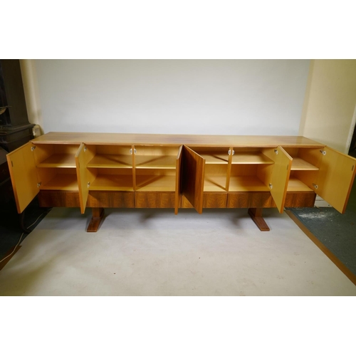 1004 - A mid century Danish style rosewood sideboard, with six cupboards over six drawers, the interior ven... 