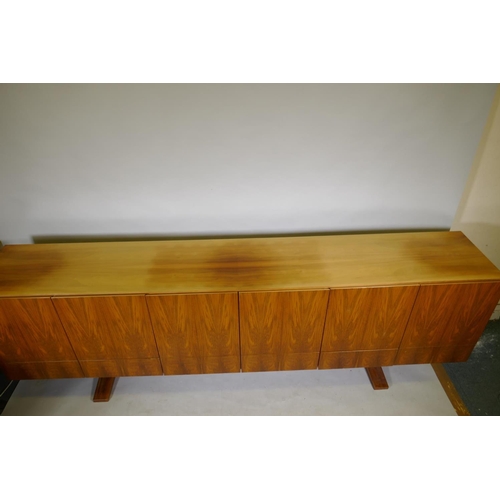 1004 - A mid century Danish style rosewood sideboard, with six cupboards over six drawers, the interior ven... 