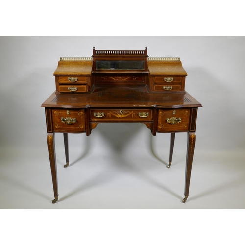 1006 - A Victorian inlaid mahogany inverted breakfront bonheure de jour, with pierced brass gallery top and... 