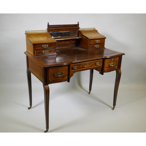 1006 - A Victorian inlaid mahogany inverted breakfront bonheure de jour, with pierced brass gallery top and... 