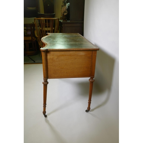 1009 - A Victorian satinwood serpentine front five drawer kneehole dressing table, with inset leather top, ... 