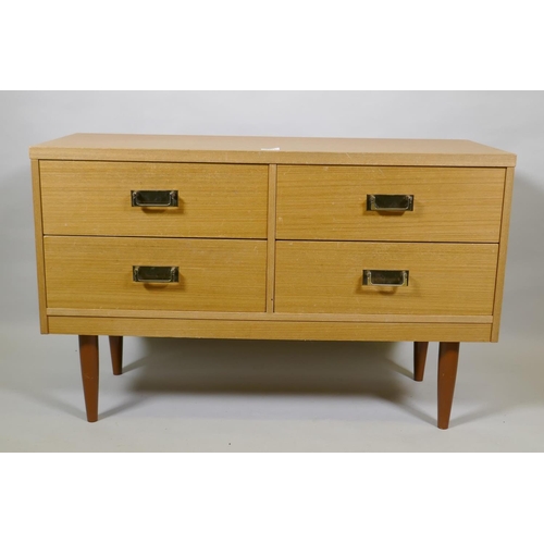 1014 - A mid century faded sapele four drawer chest with brass handles, raised on tapering supports, 101 x ... 