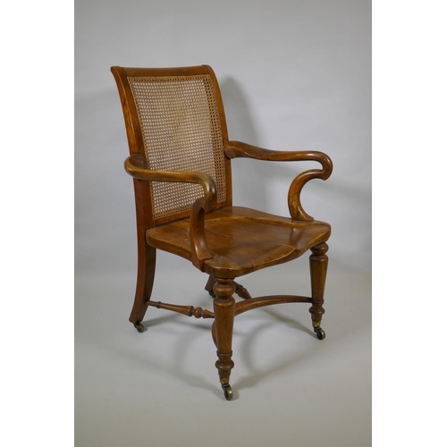 1016 - An early C19th Irish walnut elbow chair with bergere caned back, shepherd's crook arms and saddle se... 