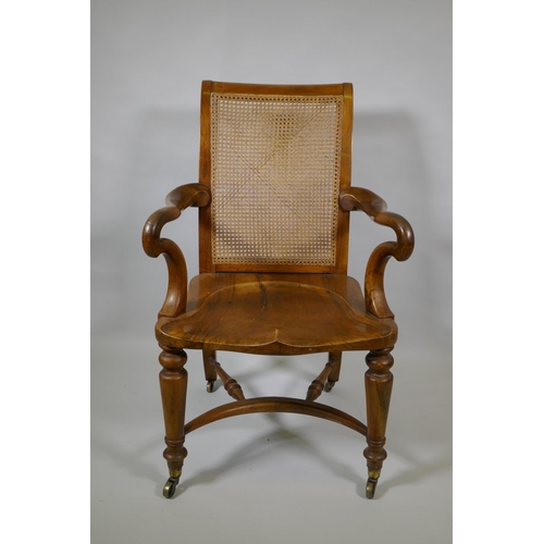 1016 - An early C19th Irish walnut elbow chair with bergere caned back, shepherd's crook arms and saddle se... 