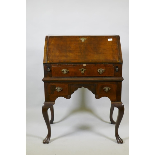 1022 - A Georgian style walnut kneehole bureau, the fall front with fitted interior over a single drawer an... 