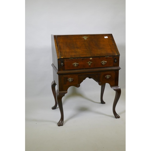 1022 - A Georgian style walnut kneehole bureau, the fall front with fitted interior over a single drawer an... 