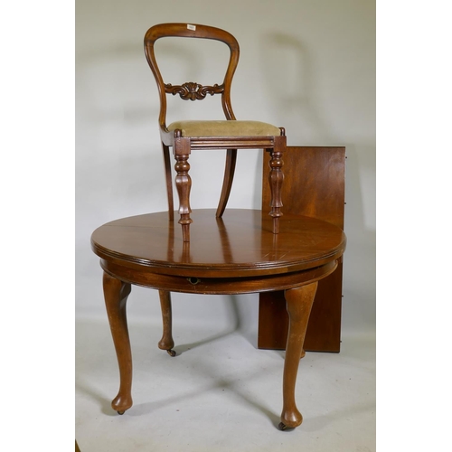 1027 - A mahogany wind out dining table, 109cm diameter, with extra leaf, raised on cabriole supports, and ... 