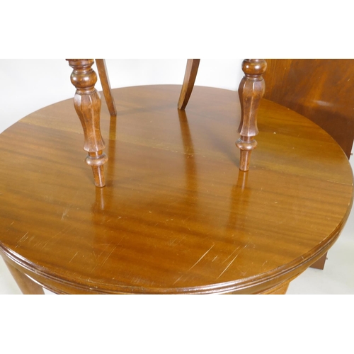 1027 - A mahogany wind out dining table, 109cm diameter, with extra leaf, raised on cabriole supports, and ... 